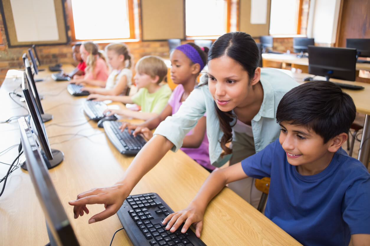 Teacher helping a student with their reading software program